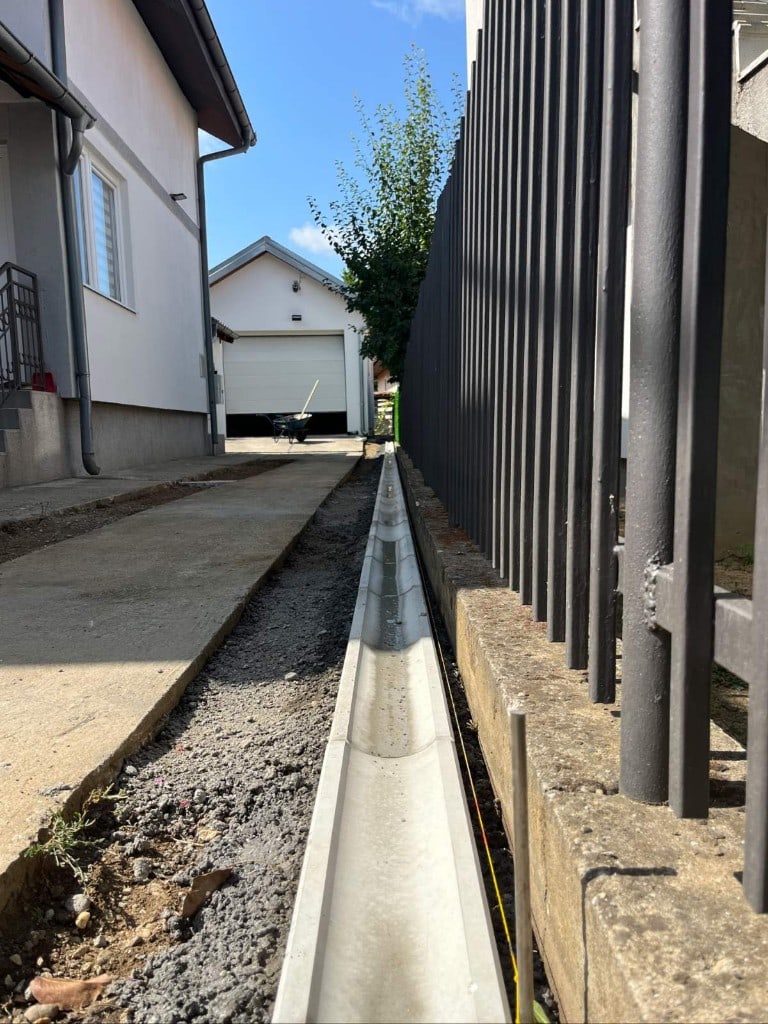 Ugradnja betonskih kanala za odvodnjavanje tokom pripreme terena za asfaltiranje
